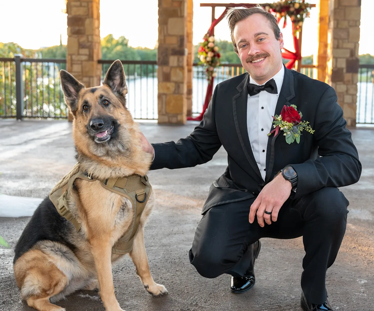 Philip in a tuxedo kneeling next to Shelby at the wedding